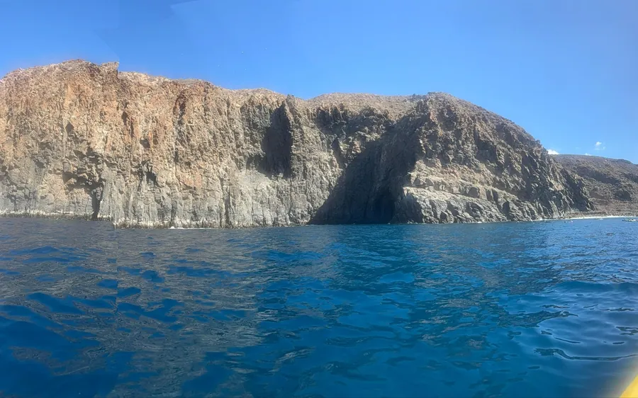 Sea cliffs with cave openings above deep blue water