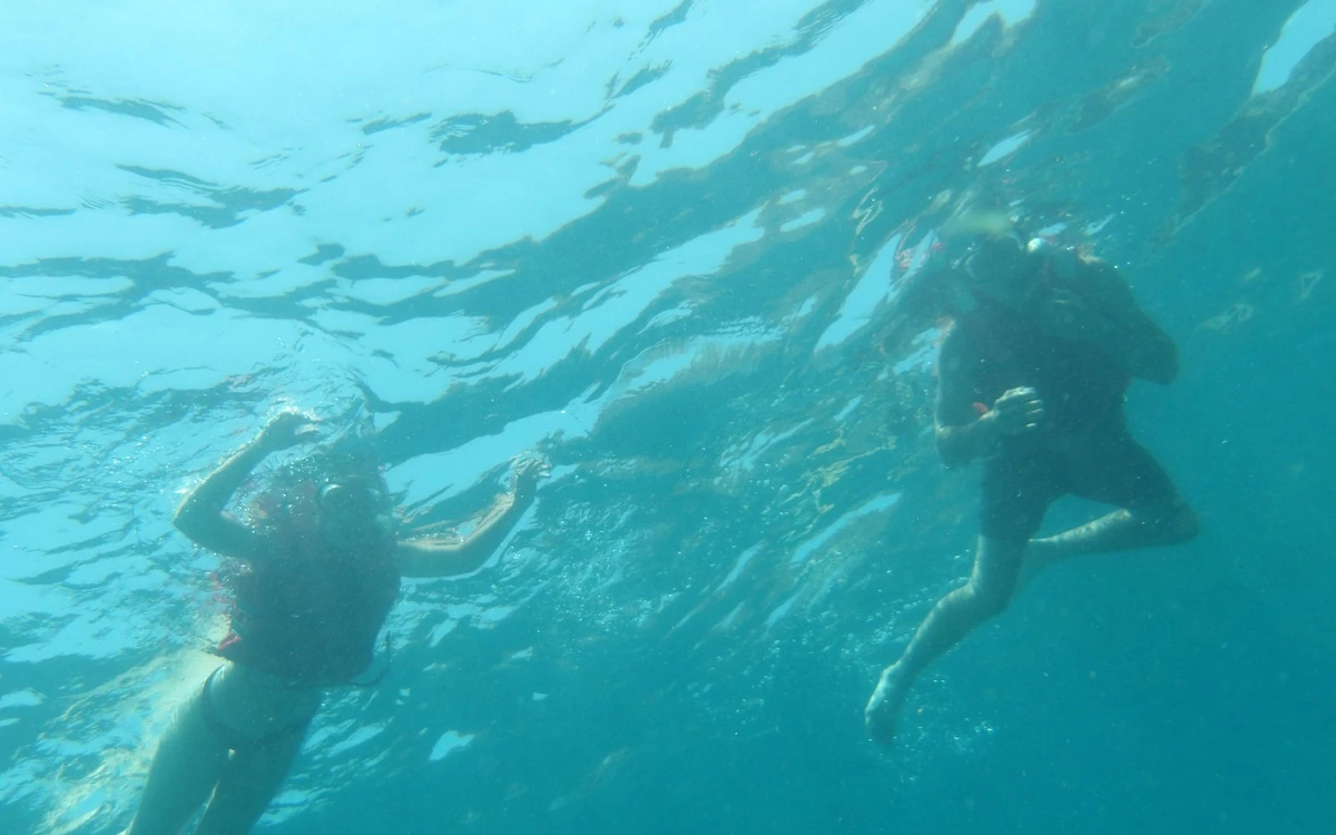 Two people snorkelling under clear turquoise water