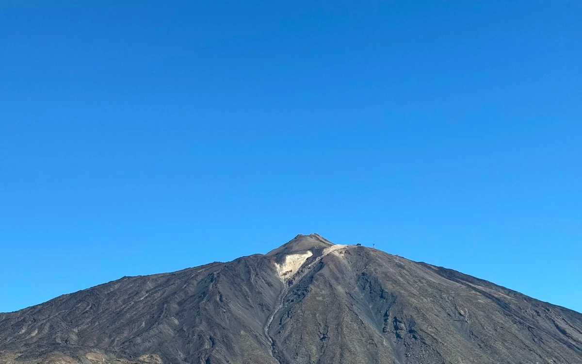 The bare grey slopes of Teide against a cloudless blue sky